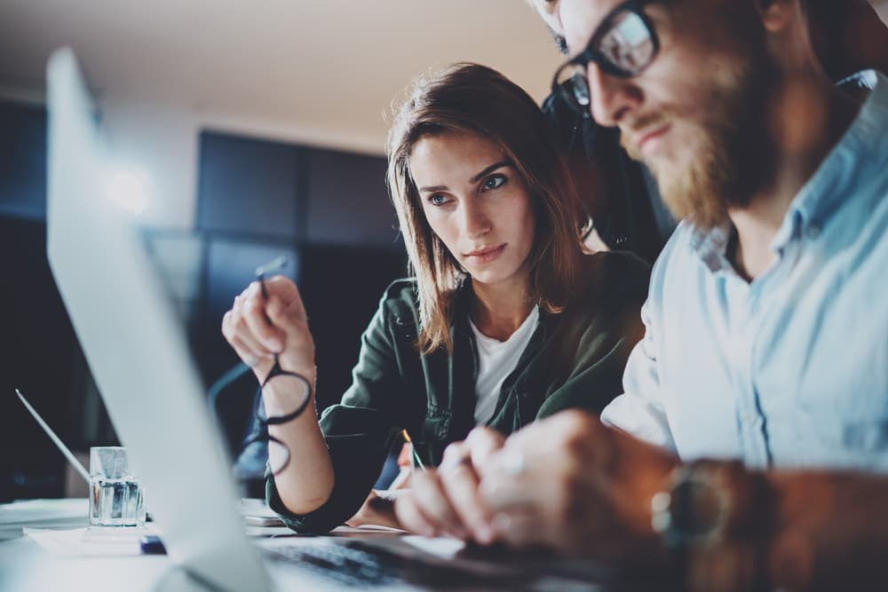 two people speaking in front of laptop